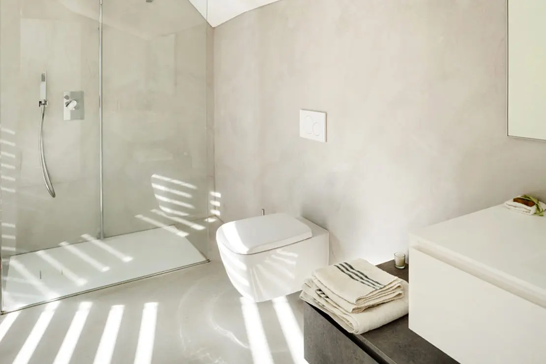 Salle de bain avec sol et murs en béton ciré de couleur claire à Grenoble